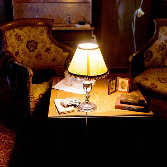 Deux fauteuils à motifs et lampe allumée sur une table de chevet, salle Titanic chez Prisme Escape Game à Laxou