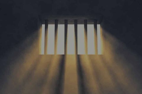 Cellule carcérale avec barreaux et lumière filtrée, chez La Loge du Temps à Mulhouse