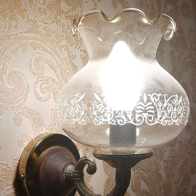 Applique murale classique avec globe blanc ajouré dans L'Hôtel des oubliés