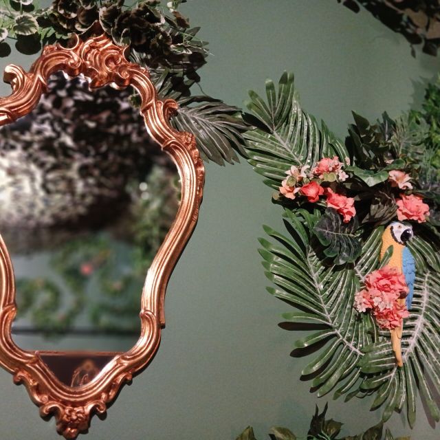 Miroir doré baroque et perroquet parmi les feuillages, La Malle de la Serre Royale