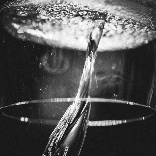 De l'eau jaillit d'une structure circulaire dans l'obscurité à L'héritage des bulles