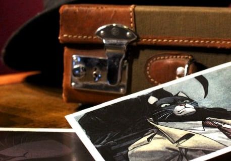 Valise vintage, photographie en noir et blanc et chapeau sur surface sombre, ambiance enquête privée