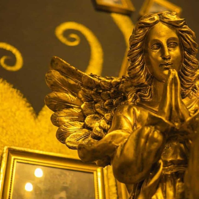 Statuette dorée d'ange aux ailes déployées dans le décor de la salle
