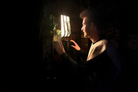 Jeune homme éclairé par une fenêtre lumineuse dans une pièce noire, visuel de Norden Escape à Calais