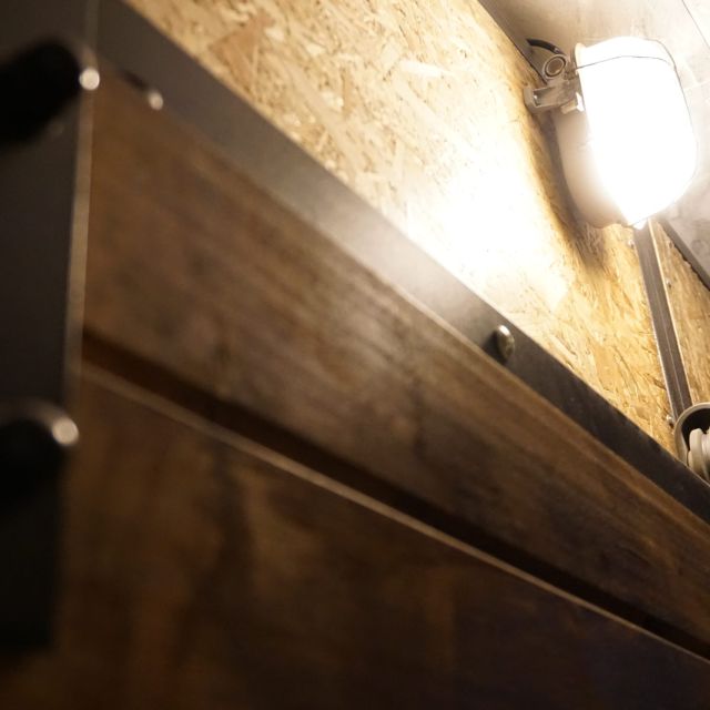 Couloir souterrain avec murs en pierre, lampe appliquée et ambiance caverneux dans Des intrus dans la mine
