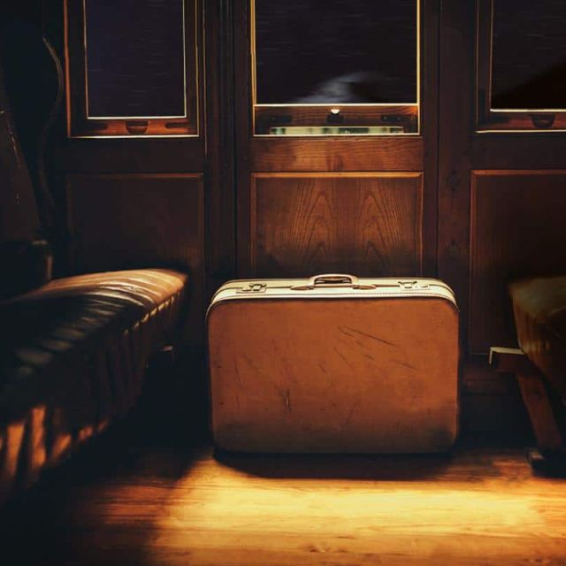 Intérieur rétro d'un train avec valise vintage et sièges en cuir dans Budapest Express