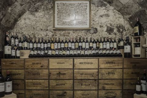 Cave voûtée en pierre avec casiers de bouteilles de vin alignés, salle In Vino Veritas chez La Clef à Bergerac