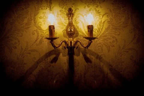 Candélabre doré sur papier peint damassé dans LE MANOIR DES SŒURS AUBÉPINE