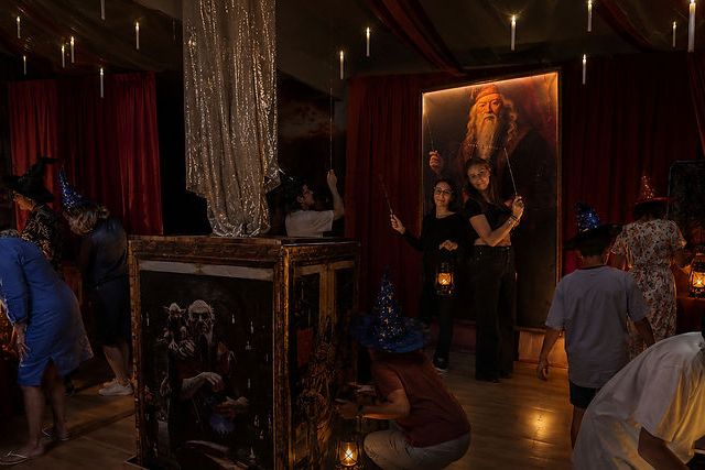 Salon aristocratique aux rideaux rouges, joueurs explorant un décor gothique dans L'Heritage de Dumbledore