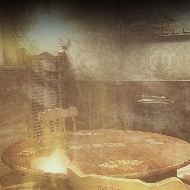 Table ronde et chaises en bois dans une pièce sombre aux tons sépia, salle L'Odyssée chez Échappe Toi Si Tu Peux