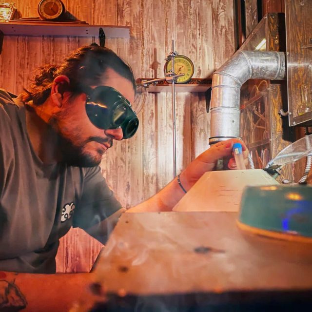 Joueur à lunettes de protection et tuyaux métalliques dans un atelier boisé, salle Retour dans le temps chez Freeing à Saint-Maximin