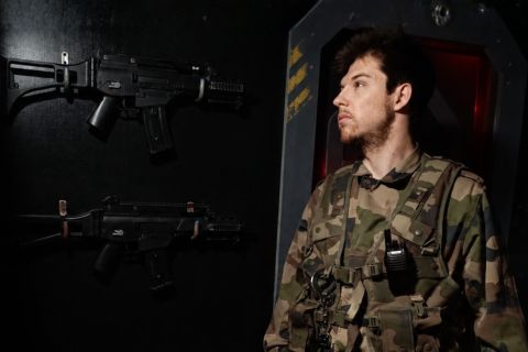 Soldat en tenue de combat dans un bunker futuriste équipé d'armes, chez Le Kraken