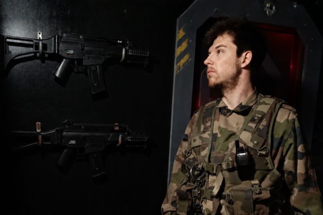 Soldat en tenue de combat dans un bunker futuriste équipé d'armes, chez Le Kraken