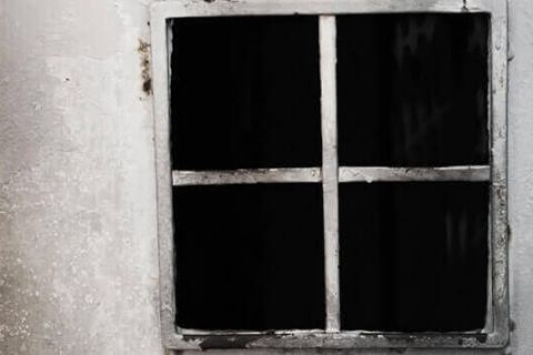 Fenêtre aux vitres brisées d'une cellule de prison dans PRISON ROOM