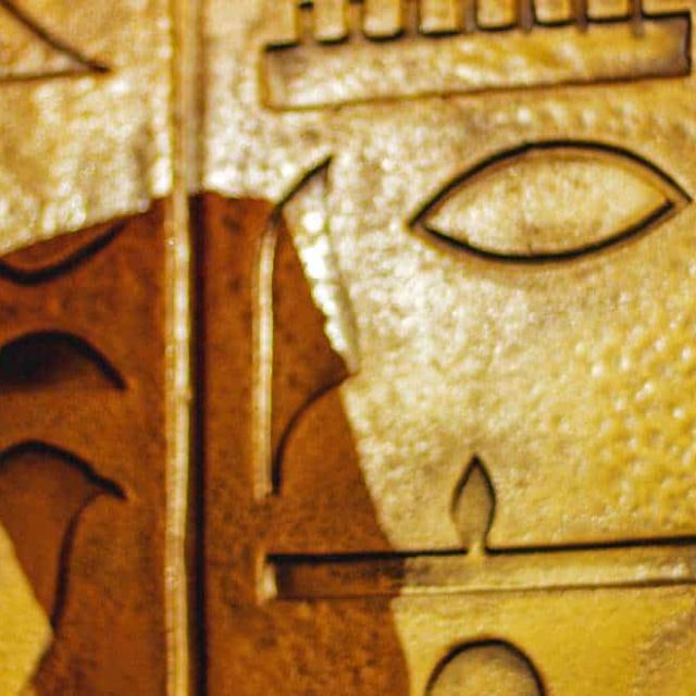Buste égyptien noir à coiffe bleue devant des hiéroglyphes dorés, salle Pharaon chez Escape Yourself à Pornichet