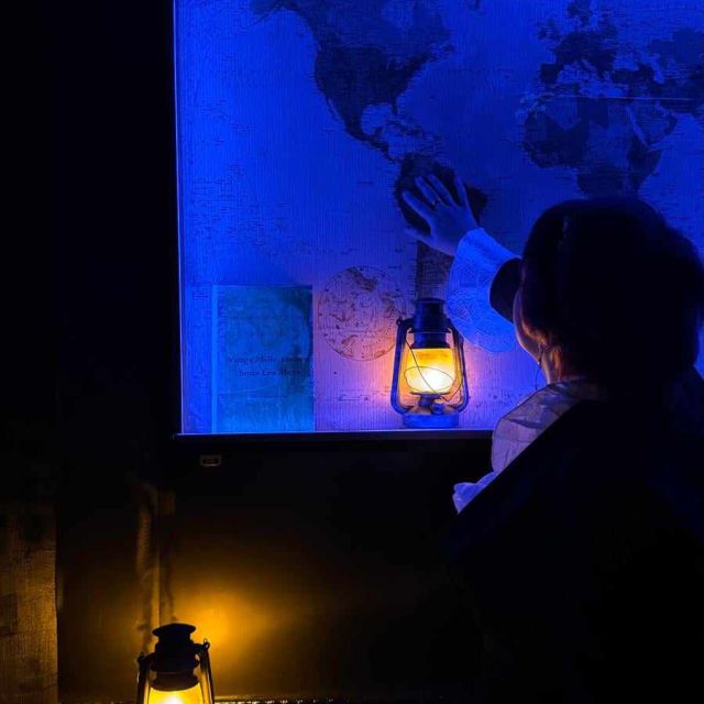 Joueur face à un écran bleu avec carte, globe et lanterne jaune, ambiance sous-marine du Nautilus