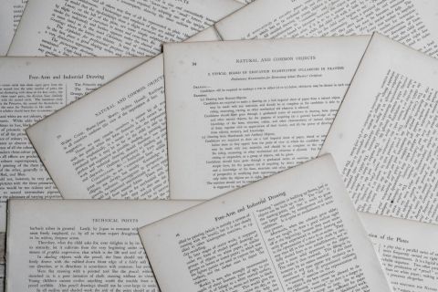 Pages de livre imprimées éparpillées en gros plan, visuel de l'enseigne Mystère et Compagnie au Havre