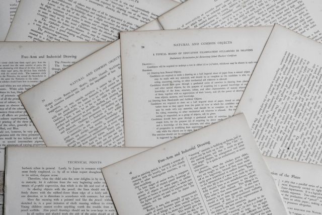 Pages de livre imprimées éparpillées en gros plan, visuel de l'enseigne Mystère et Compagnie au Havre