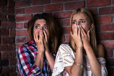 Deux jeunes femmes effrayées, mains sur la bouche, devant un mur de brique, salle Où est Jessy chez Crazy Rooms