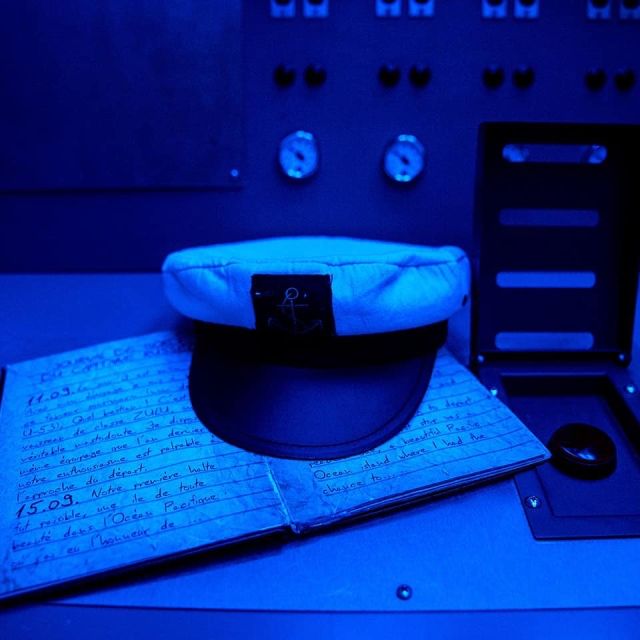 Casquette de marin posée sur un journal de bord ouvert, salle Mission Torpédo au Portel