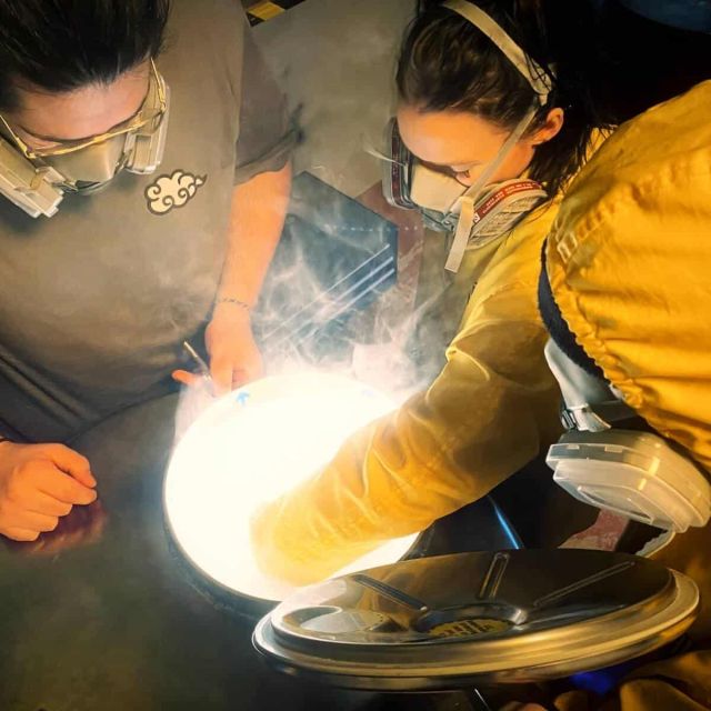 Deux joueurs examinent un objet luminescent sous protection à Breaking Lab