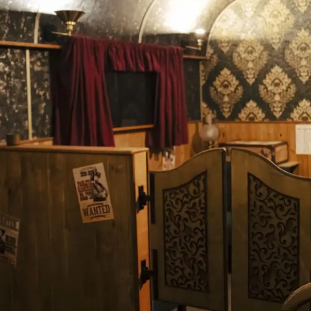 Saloon avec portes battantes, papier peint sombre, lambris et avis de recherche, salle Le Silver Express à Pertuis
