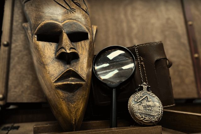 Masque en bois sculpté, loupe et montre à gousset, contenu du coffre Le mystère du serpent d'or