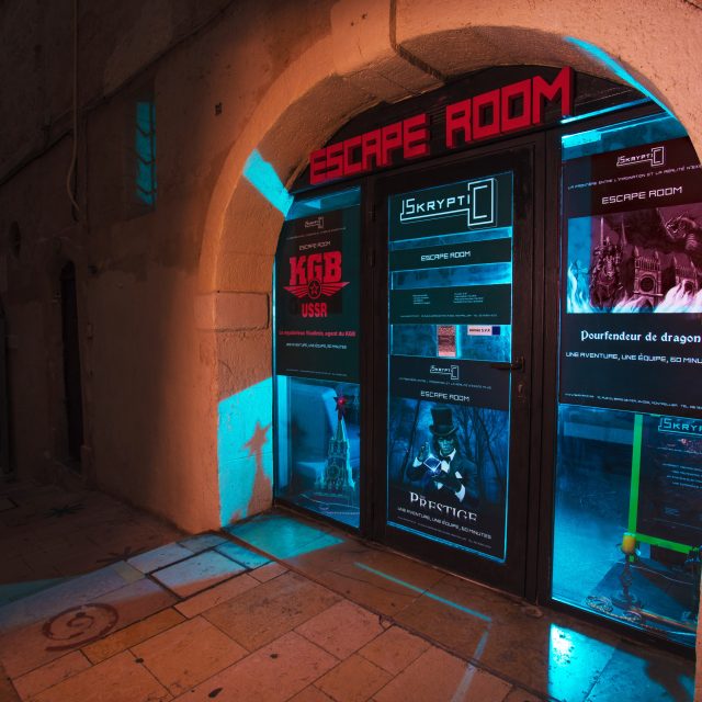 Devanture de Skryptic Escape Game à Montpellier, néons bleus et rouges sous une voûte
