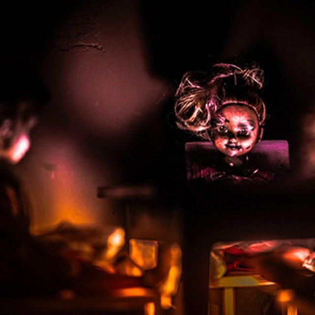 Visage d'une poupée ancienne dans la pénombre, lueurs rouges, salle Le manoir sinistre chez Freeing à Saint-Maximin