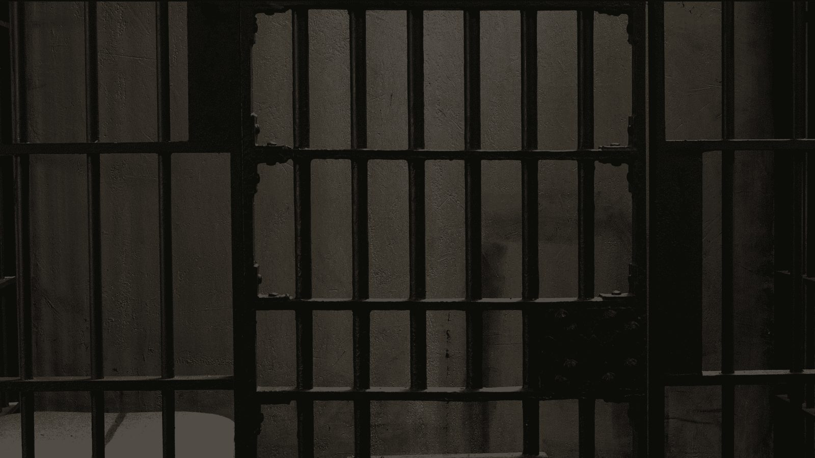 Barreaux de prison massifs formant une cellule grise et austère chez Espace escape à Lattes