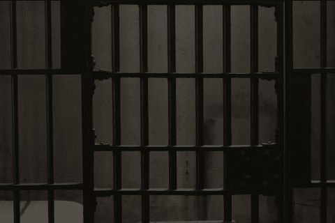 Barreaux de prison massifs formant une cellule grise et austère chez Espace escape à Lattes