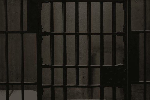 Barreaux de prison massifs formant une cellule grise et austère chez Espace escape à Lattes