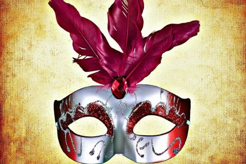 Masque de carnaval argenté à plumes bordeaux sur fond jaune patiné, salle O Vaval chez Tictac Escape Game à Baie-Mahault