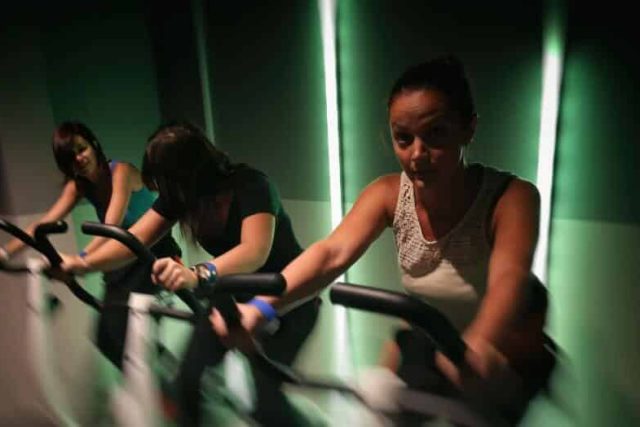 Trois joueurs manipulent des objets dans un couloir aux néons verts chez Techno et logic