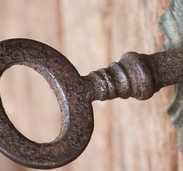 Gros plan d'une clé de fer dans une plaque de serrure décorée, escape game Le Mystère à Batilly-en-Puisaye