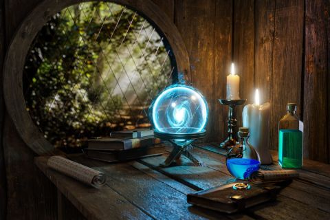 Fenêtre ronde sur un jardin, boule de cristal bleue, bougies et fioles sur une table, salle Sortilèges interdits chez Mind and Run
