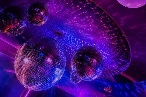 Boules à facettes sous une lumière violette au plafond du Pandore Palace, explore game à Paris
