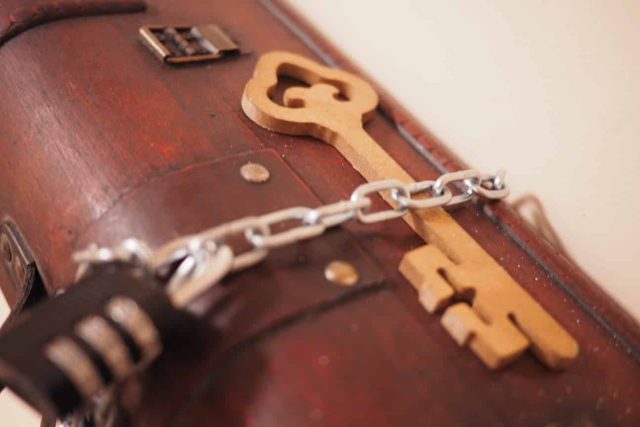 Clés en bois et chaîne métallique sur valise vintage, L'atelier du musicien