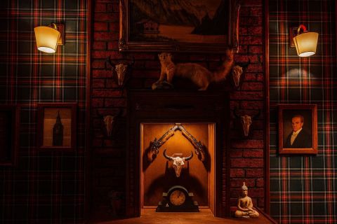 Décor écossais avec cheminée, trophées de chasse et portraits dans Escape with Sherlock
