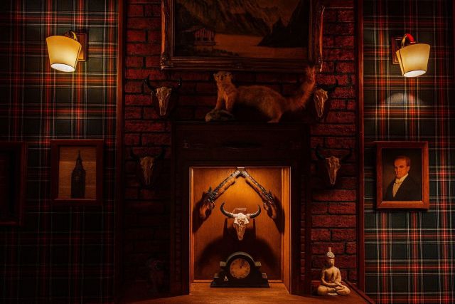 Décor écossais avec cheminée, trophées de chasse et portraits dans Escape with Sherlock