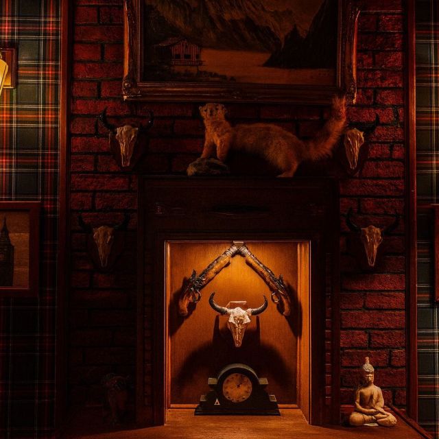Intérieur écossais aux murs de pierre rouge, trophées et crânes d'animaux empaillés, ambiance chasse