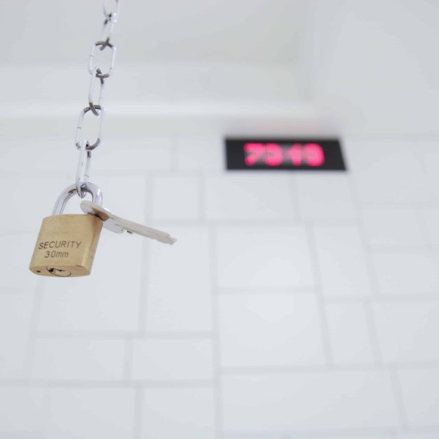 Cadenas de sécurité suspendu à une chaîne devant panneau rose chez LockedUp Lieusaint