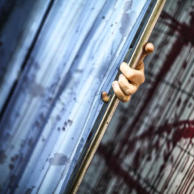 Main qui actionne une poignée de porte rouillée dans l'asile abandonné Freeing!