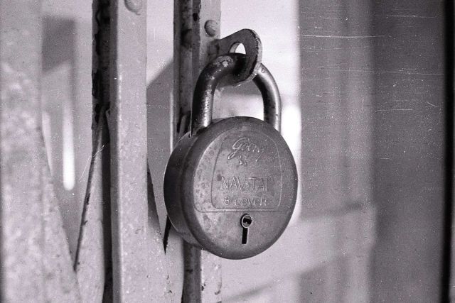 Gros cadenas métallique accroché à une porte, en noir et blanc, salle Braquage à l'espagnole, Play and escape