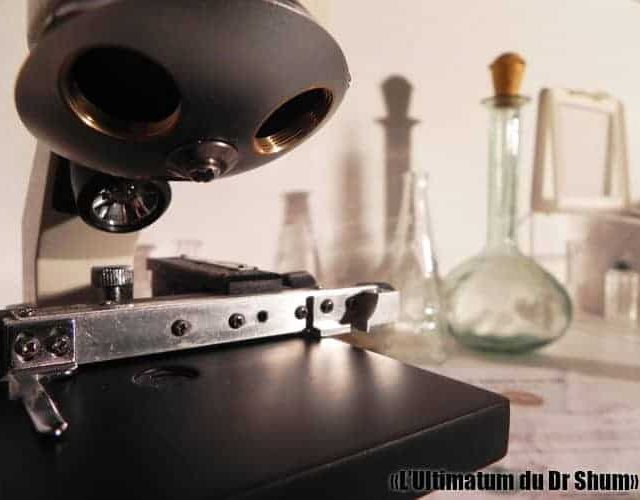 Établi du Dr Shum avec microsope, fioles et instruments scientifiques dans L'Ultimatum du Dr SHUM