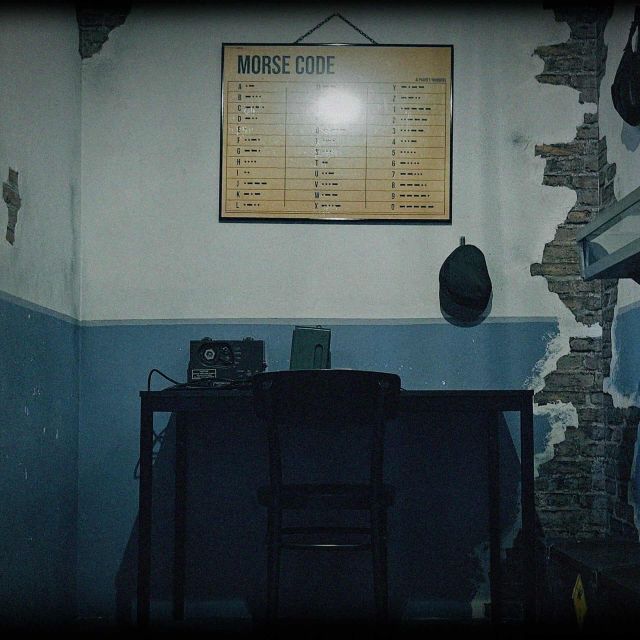 Poste radio, table métallique et affiche Morse dans bunker soviétique délabré chez Freeing! à Chambly