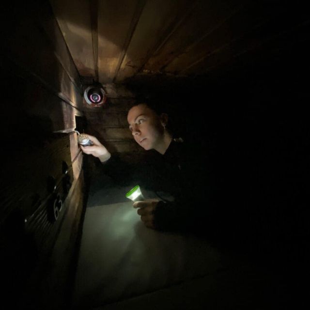 Joueur muni d'une lampe torche explorant une cellule souterraine sombre chez Freeing!