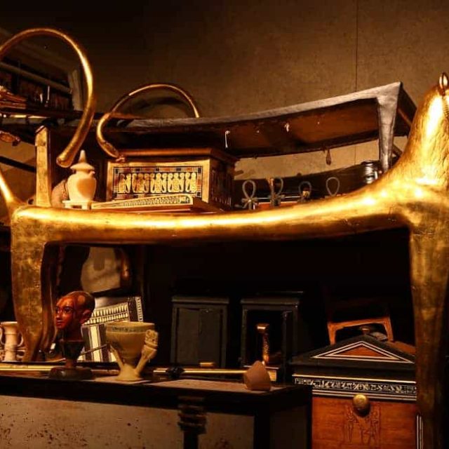 Décor égyptien avec sarcophage doré, objets archéologiques et hiéroglyphes au Mystère Nerfertiti