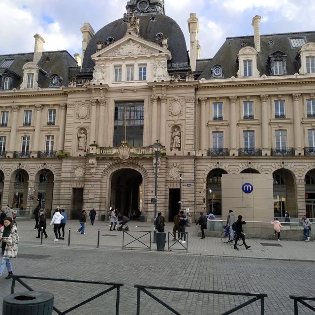 Grande façade classique à dôme et colonnes sur une place animée, salle Le blason au lion d'or, Hunting Town à Rennes