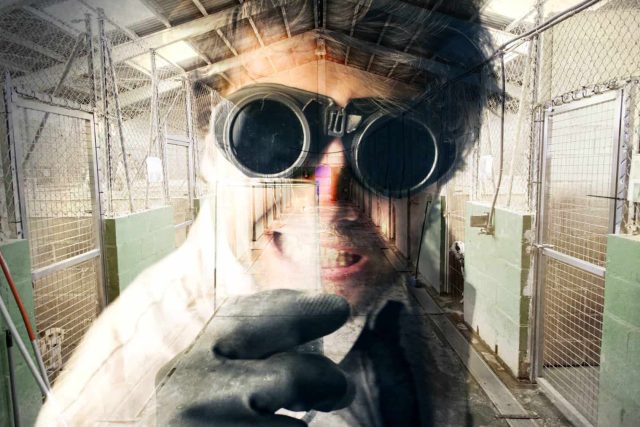 Couloir industriel avec énormes yeux mécaniques et pneus usagés dans la prison du Chenil